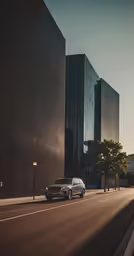 two cars drive past large buildings on the street