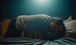 a man with his head on a pillow while he lays down