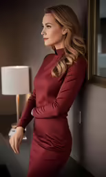 a woman wearing red standing in front of a mirror
