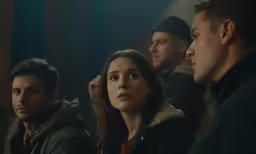 a group of people are standing together in the dark