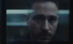 man with facial features looking into a window