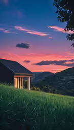a pink sunset with the sun peeking out from behind a house