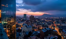 view of buildings at night, with the city in the distance