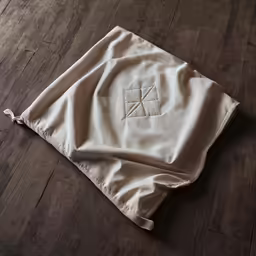 the monogrammed monogramed logo on a bag lies across a wood floor