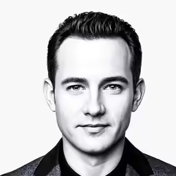 a man in a suit and tie looks into the camera