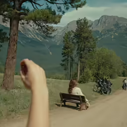 a person holds their hand over a bench in the road