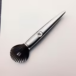 a metal brush sitting on top of a paper