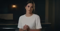 a young lady is standing against a black background