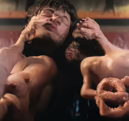 two naked people lying side by side on a couch