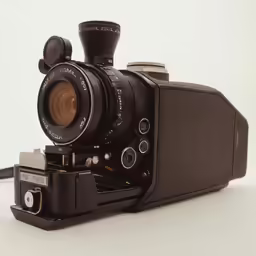 an old fashioned film camera sitting on a white surface