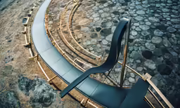 the curved outdoor bench has gold bars on it