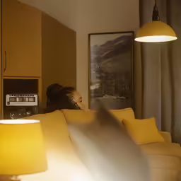 a lady sitting on a couch watching television
