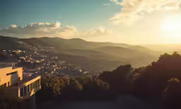 the sun rises over a hill side with many trees