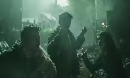 the three people are standing next to each other in the woods