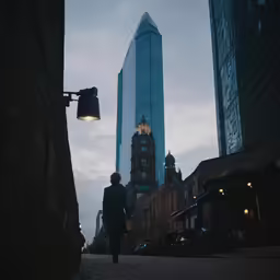 a person walking on a street past tall buildings