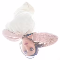 a woman looks up at the camera while wearing white clothes