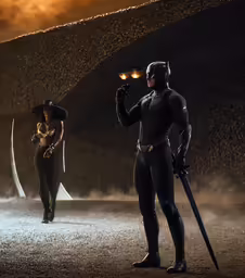a man standing next to another man in the dark