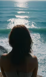 girl looking out at the ocean while sitting