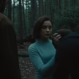 two people walking through a forest