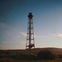 the sun rising at a tall tower like structure