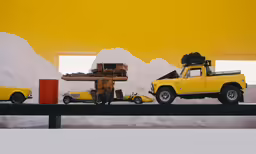 two yellow trucks on an assembly line near snow