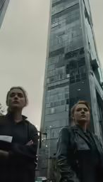 three people are standing outside of an apartment building