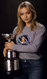 a woman posing with her trophy against a black background