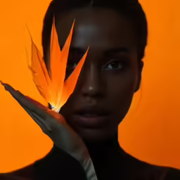 an african woman holding up a flower on her hand