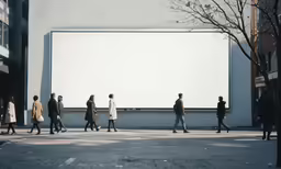 group of people walking down a sidewalk next to a large sign