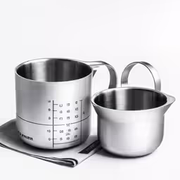 two pots sitting on top of a measuring scale