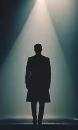 a man standing in front of a light with his back turned