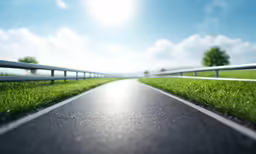 an empty road that is going through a grassy field