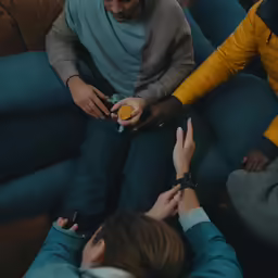 several people sitting down with their hands on something