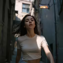 a woman walking through a narrow alleyway wearing a crop top