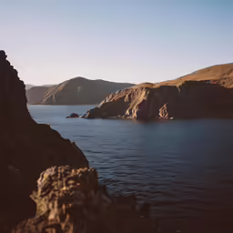the mountains and the water look out onto the hills