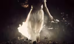 a woman walking towards the camera with her long hair in blowing wind