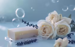 an image of soap and flowers on a white surface