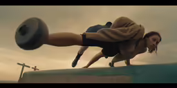 a girl doing a back split while a man lifts a barbell