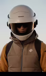 the helmet is up on his jacket as he stands
