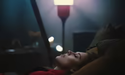 a woman laying in bed with her eyes closed