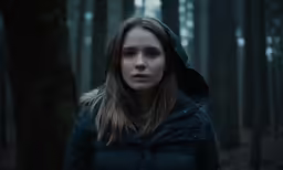 a woman with dark hair in a forest