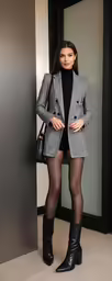 a woman in black and white dress and high heel boots
