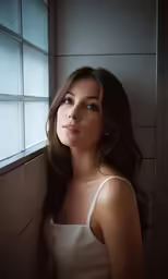 a woman poses in front of the window