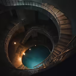a spiral staircase leading down to a pool