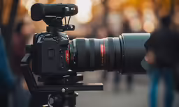 a black camera with a long lens attached to it