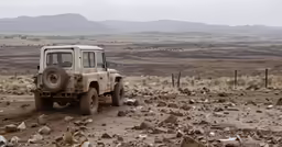 a truck drives through a dusty desert landscape