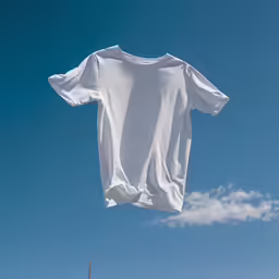an old white t - shirt being hung by someone