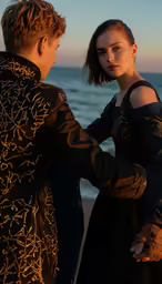a man standing next to a woman near the ocean