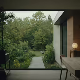 the entrance to a living room overlooking trees and a path