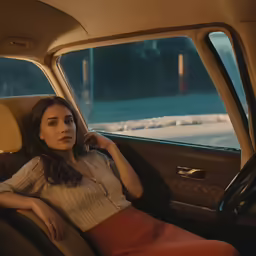 a beautiful young woman sitting in the backseat of a car